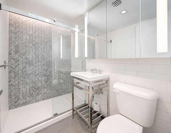 A white bathroom with a sink and mirror.