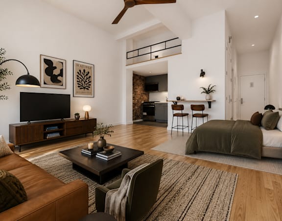 A living room with a brown leather couch and a television on a wooden stand.