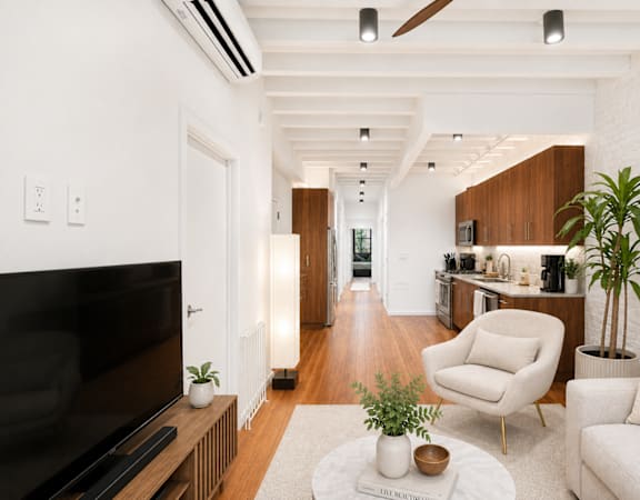 A living room with a white couch, a television, and a coffee table.