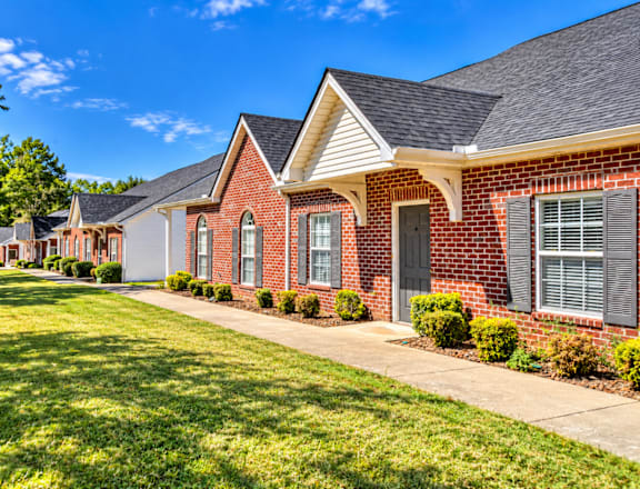 A row of houses with green lawns in front.