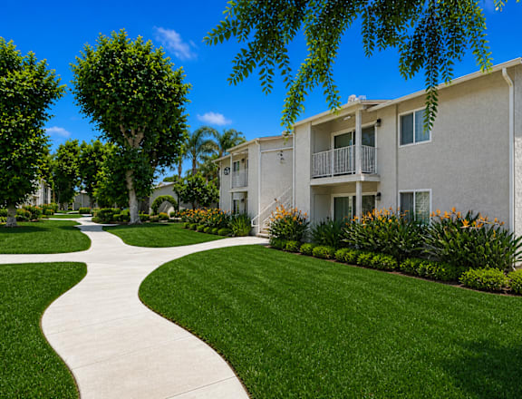 A white building with a green lawn in front.
