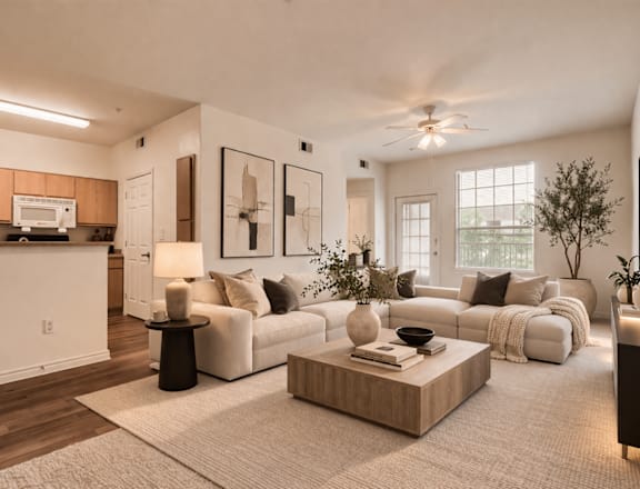 A modern living room with a white couch, a wooden coffee table, and a ceiling fan.