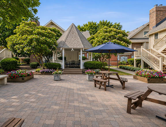 A courtyard with a gazebo surrounded by houses and trees.