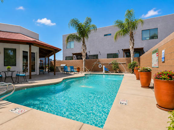 A pool with a red roof and a building behind it.