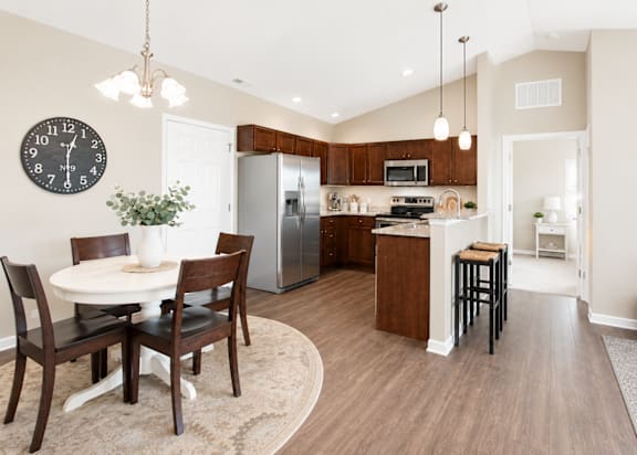 A kitchen with a table and chairs in the middle of the room.
