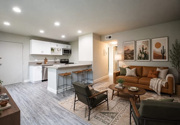 A modern living room with a kitchen in the background.