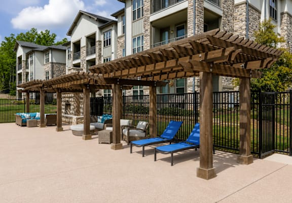 Shaded poolside pergola with lounge seating beside the swimming pool at Auberge of Tyler.