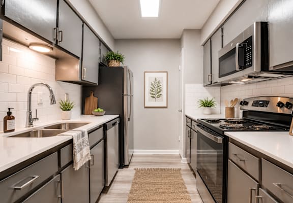 A modern kitchen with black cabinets and stainless steel appliances.