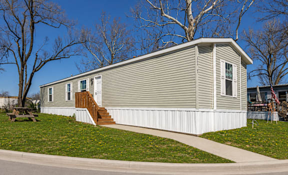 A house with a grey siding and a white trim.