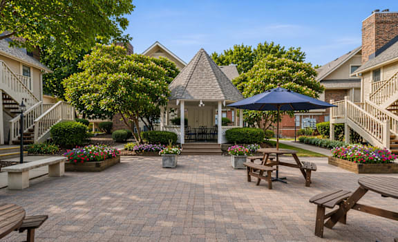 A courtyard with a gazebo surrounded by houses and trees.