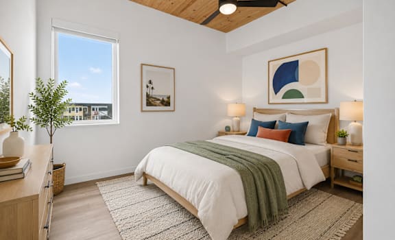 A bedroom with a bed, nightstands, and a ceiling fan.