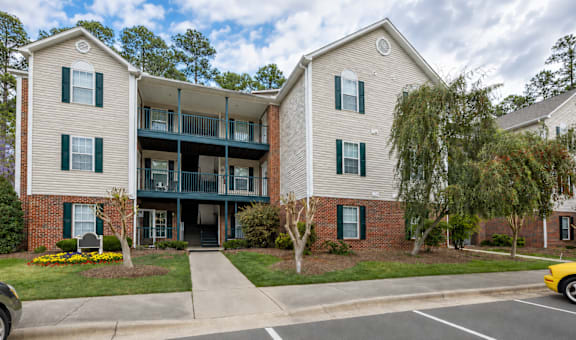 A two-story apartment building with a parking lot in front.