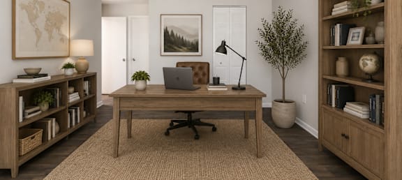 A room with a desk, chair, and bookshelves.