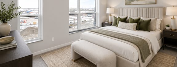 A bedroom with a large bed and a view of the city.