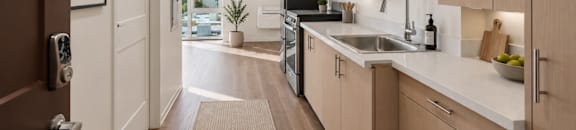 A modern studio kitchen with wooden cabinets and a white countertop.
