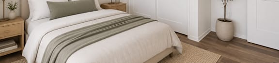 A studio bedroom with a large bed and a painting on the wall.