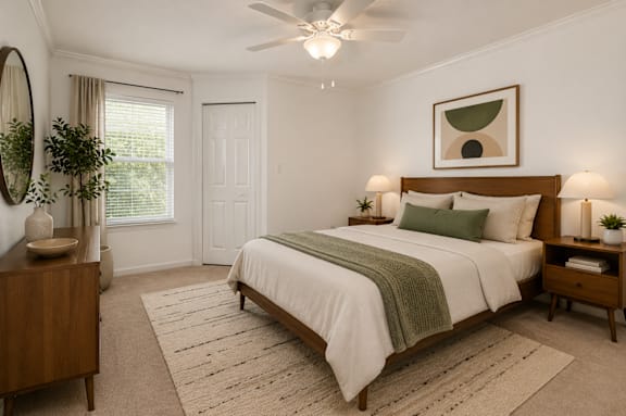 A bedroom with a large bed, a wooden dresser, and a ceiling fan.