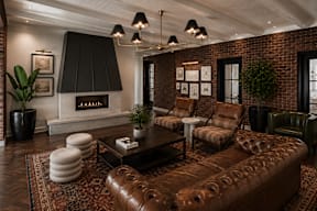 A living room with a brown leather couch and a fireplace.
