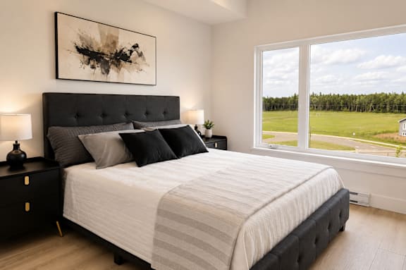 A bedroom with a large bed and a painting on the wall.