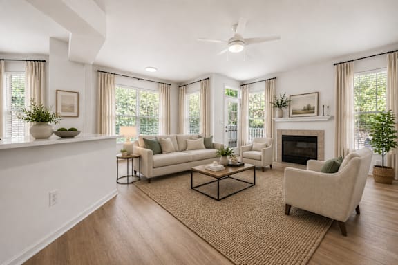 A living room with a fireplace, couch, and plants.