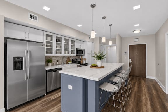 A modern kitchen with a large island and stainless steel appliances.