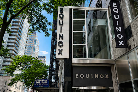 A restaurant named Equinox is located in a city with tall buildings.