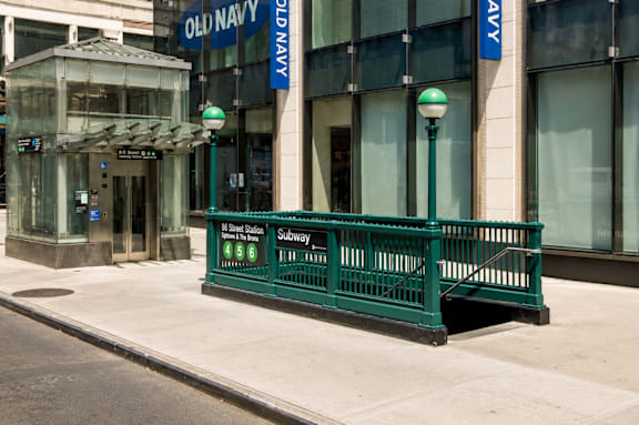 A green metal fence in front of a building with a sign that says "Old Navy".
