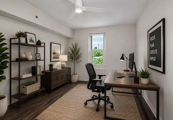 A well-lit office space with a desk, chair, and shelving unit.