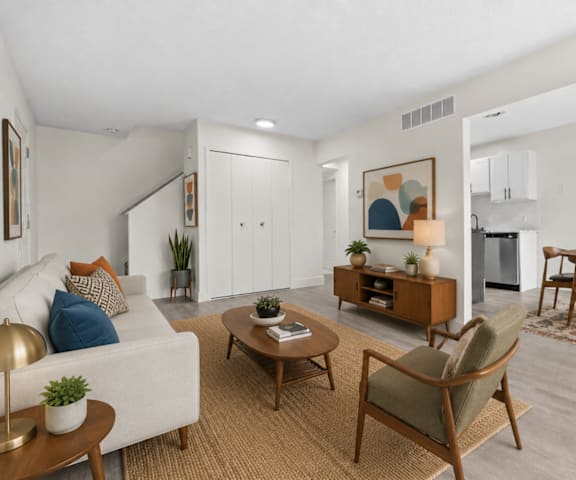 A living room with a white couch, a coffee table, and a dining table.
