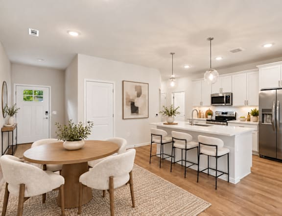A modern kitchen with a dining table and chairs.