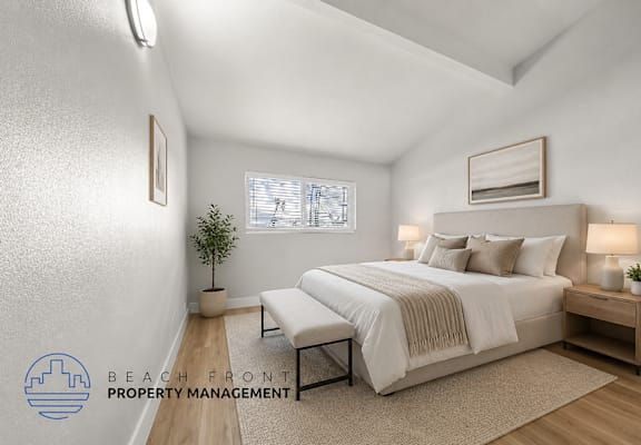 A well-lit bedroom with a large bed and a small plant on the side table.