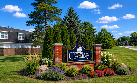 A sign that says Crystal Bay in front of a grassy area.