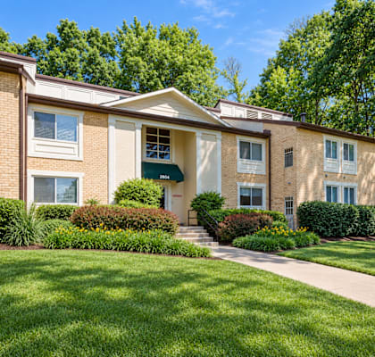 A building with a green lawn in front.