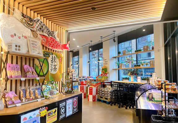 A store with a variety of goods on display and a shopping cart in the foreground.
