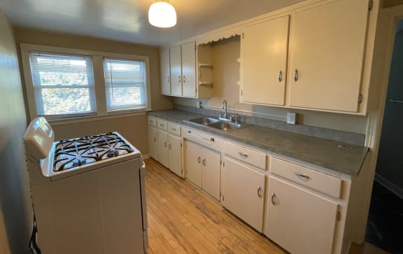 a kitchen with white cabinets and a stove top oven