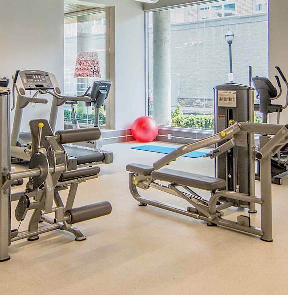 A gym with a red ball and a treadmill.
