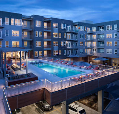 A large apartment complex with a pool and a bar.