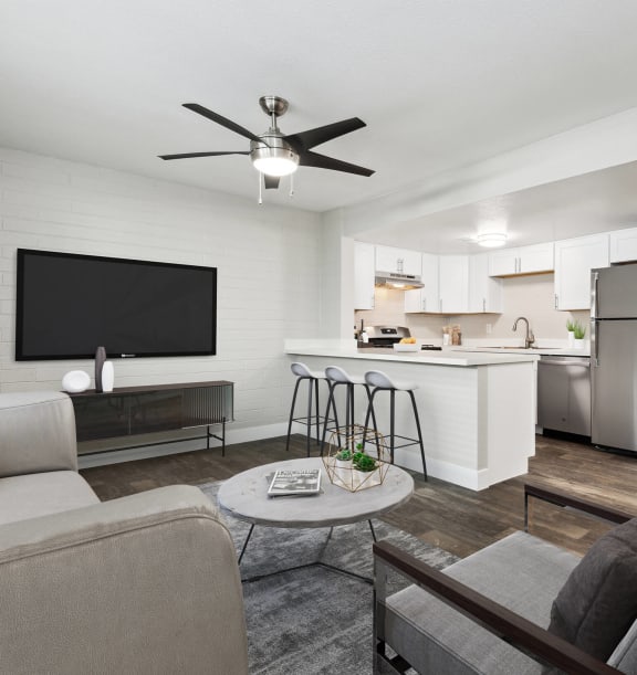 Model Living Room with Wood-Style Flooring and View of Kitchen at Arcadia on 49th Apartments located in Phoenix, AZ-WELCOME.