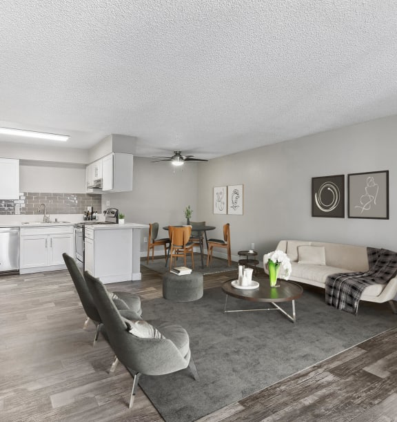 Model Living Room with Wood-Style Flooring and View of Kitchen at Meadow Ridge Apartments located in Las Vegas, NV-WELCOME.
