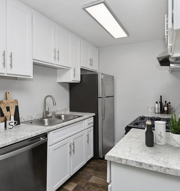 Model Kitchen with White Cabinets and Wood-Style Flooring at The Meritage Apartments in Vallejo, CA-WELCOME.