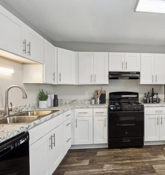 Model Kitchen with White Cabinets and Wood-Style Flooring at Parc at Creekside Apartments in Kansas City, MO-WELCOME.