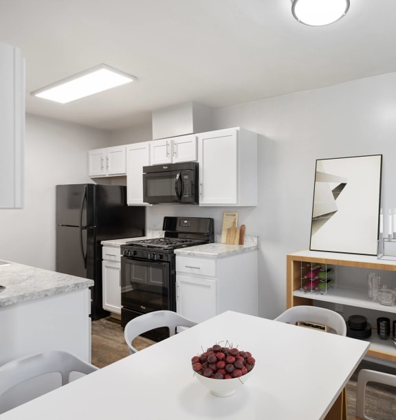 Model Dining Room and Kitchen with Wood-Style Flooring at Brightwood Forest Apartments in Dale City, VA-WELCOME.