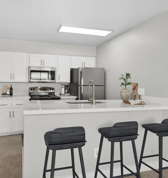 Model Kitchen with White Cabinets and Wood-Style Flooring at Crystal Creek Apartments in Phoenix, AZ-WELCOME.