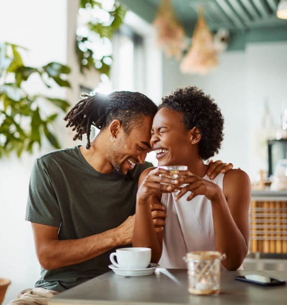 Couple sitting at a cafe table with coffee and tea