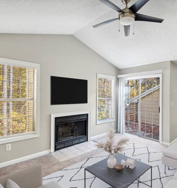 a living room with a fireplace and a ceiling fan