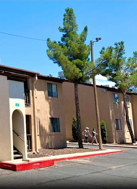 A row of beige buildings with arched doorways and windows.