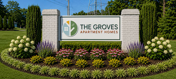 The Groves Apartment Homes sign is surrounded by a well-manicured garden.