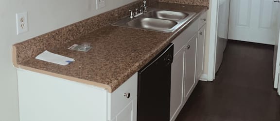 a kitchen with white cabinets and a black dishwasher