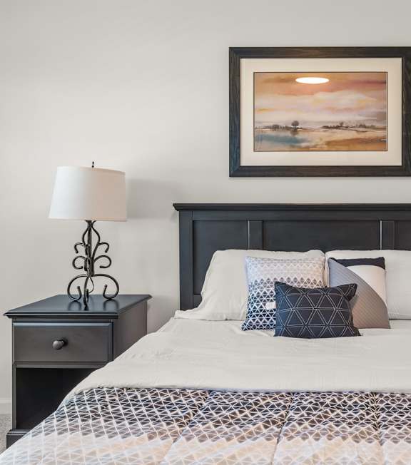 A bedroom with a large bed and a ceiling fan.
