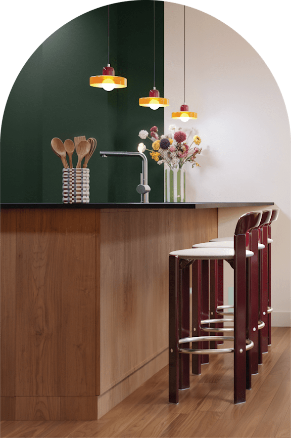 A kitchen with a green backdrop and a wooden counter.